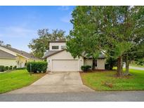 Tan two-story house with a two-car garage and mature landscaping at 172 Gull S Dr, Daytona Beach, FL 32119