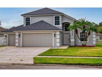 Two-story house with gray siding and a three-car garage at 5336 Georgia Peach Ave, Port Orange, FL 32128