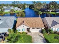 Aerial view of house near a lake with a view of neighboring houses at 803 Pine Shores Cir, New Smyrna Beach, FL 32168