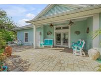 Inviting porch with teal chairs and a stone floor at 322 Columbus Ave, New Smyrna Beach, FL 32169