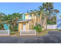 Cute yellow house with white picket fence, located in a tropical neighborhood at 4017 Saxon Dr, New Smyrna Beach, FL 32169