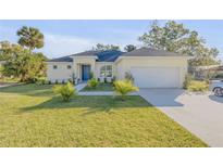 Single-story house with a two-car garage, driveway, and well-maintained lawn at 1929 Pioneer Trl, New Smyrna Beach, FL 32168