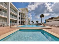 Community pool and spa with surrounding patio and lounge chairs at 3509 S Atlantic Ave # 108 & 109, New Smyrna Beach, FL 32169