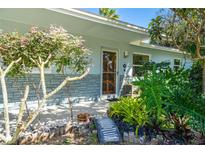 Light blue house with stone accents, lush landscaping, and a welcoming front porch at 4623 Saxon Dr, New Smyrna Beach, FL 32169