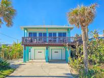Elevated beach house with two-car garage and ocean views at 6244 S Atlantic Ave, New Smyrna Beach, FL 32169