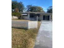 White house with a white picket fence and a long driveway at 2017 Royal Palm Dr, Edgewater, FL 32141