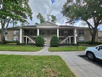 Two-story building exterior with manicured lawn and parking at 112 Reserve Cir # 104, Oviedo, FL 32765
