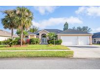 Single-story home with two-car garage and palm trees at 6283 Paradise Island Ct, Port Orange, FL 32128