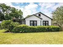 Charming white house with black trim and well-manicured lawn at 245 W Ocala St, Umatilla, FL 32784