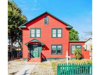 Two-story red house with green trim and picket fence at 415 Braddock Ave, Daytona Beach, FL 32118