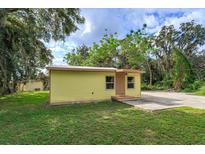 Yellow house exterior with a spacious yard at 14650 Liberty St, Orlando, FL 32826