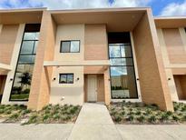 Modern two-story townhome with light brown exterior at 7577 Brooklyn Dr, Kissimmee, FL 34747