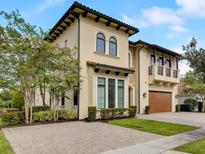 Mediterranean style home with two-car garage and manicured landscaping at 580 Muirfield Loop, Reunion, FL 34747