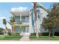 Two-story house with a light blue exterior, front porch, and lush landscaping at 1554 Fairview Cir, Kissimmee, FL 34747