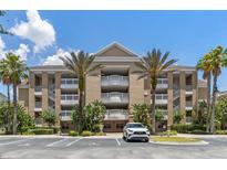 Exterior of a three-story condo building with palm trees and parking at 1106 Sunset View Cir # 201, Reunion, FL 34747