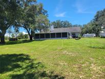 Spacious backyard with large grassy area and screened patio at 2850 Dowman Dr, Apopka, FL 32712