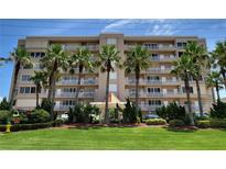 Beige multi-story building with palm trees and landscaped lawn at 4757 S Atlantic Ave # 403, Ponce Inlet, FL 32127