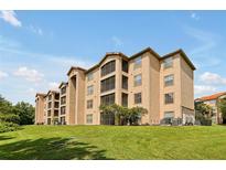 Tan three-story building with balconies and green space at 1375 Tuscana Ln # 1308, Davenport, FL 33896