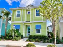 Bright green two-story home with blue shutters and landscaping at 8035 Knee Deep Rd, Kissimmee, FL 34747