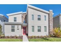 Modern two-story home with a red door and stone accents at 4509 Target Blvd, Kissimmee, FL 34746
