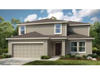 Two-story home with taupe siding, brown door, and two-car garage at 128 Citrine Loop, Kissimmee, FL 34758