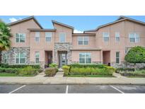 Two-story townhome with light peach exterior and landscaping at 1616 Carey Palm Cir, Kissimmee, FL 34747