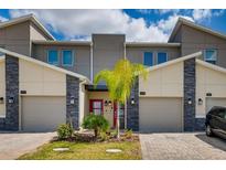 Three-unit townhome with attached garages and landscaping at 545 Ocean Course Ave # 545, Davenport, FL 33896