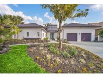 Modern two-story house with a three-car garage and landscaped yard at 9217 Hidden Bay Ln, Orlando, FL 32819