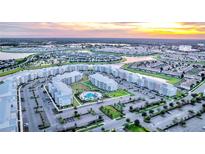 Aerial view of an apartment complex with a pool at sunset at 3111 Paradox Cir # 406, Kissimmee, FL 34746