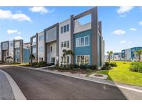 Modern townhome community with teal and gray buildings at 7740 Sandy Ridge Dr # 132, Reunion, FL 34747