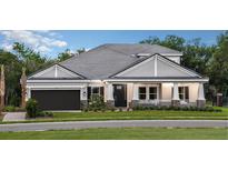 A charming one-story house with gray siding and a dark brown garage door at 1400 Arklow Cir, Ormond Beach, FL 32174
