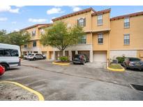 Exterior view of townhouses with parking and lush landscaping at 6119 Metrowest Blvd # 106, Orlando, FL 32835