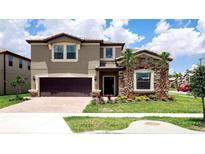 Two-story home with stone accents and a two-car garage at 8801 Corcovado Dr, Kissimmee, FL 34747