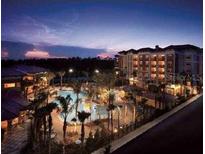 Night view of resort community with multiple buildings and pools at 12538 Floridays Resort Dr # 401-C, Orlando, FL 32821