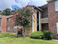 Condo building with landscaping and walkway at 5635 Devonbriar Way # 103, Orlando, FL 32822