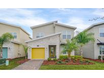 Modern two-story home with a yellow garage door and landscaped front yard at 751 Drop Shot Dr, Davenport, FL 33896