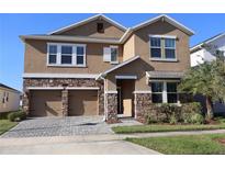 Two-story house with two-car garage and stone accents at 3060 Prelude Ln, Kissimmee, FL 34746