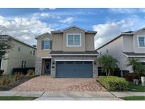 Two-story house with stone accents and a two-car garage at 7405 Marker Ave, Kissimmee, FL 34747