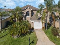 Two-story house with a two-car garage and palm trees at 2881 Kokomo Loop, Haines City, FL 33844