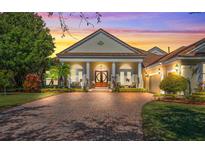 Elegant home exterior with brick driveway and lush landscaping at 6443 Cartmel Ln, Windermere, FL 34786