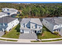 Two-story house with attached garage and landscaping, in a neighborhood, aerial view at 1758 Oak Blossom Dr, Davenport, FL 33837