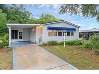 Front view of a single-story home with a covered porch and driveway at 538 Saint Andrews Blvd, The Villages, FL 32159