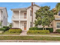 Two-story home with a front porch and landscaped yard at 7768 Linkside Loop, Reunion, FL 34747