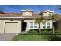 Tan two-story townhome with a two-car garage at 1165 Trappers Trail Loop, Davenport, FL 33896