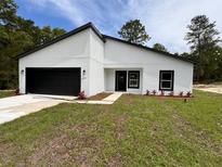 Modern home exterior with a black and white color scheme and landscaped yard at 14759 Sw 43Rd Terrace Rd, Ocala, FL 34473