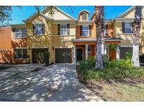 Tan and orange townhome with two car garage at 868 Assembly Ct, Reunion, FL 34747