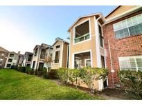 Exterior view of a condo building, showing the building's architecture and landscaping at 5530 Chrishire Way # D-210, Orlando, FL 32822