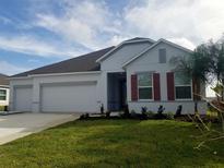 Newly built home with a three-car garage and red shutters at 204 Barrington Dr, Haines City, FL 33844