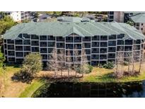 Multi-story building with a green roof and surrounding landscape at 9055 Treasure Trove Ln # 204, Kissimmee, FL 34747