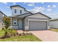 Charming two-story home with gray siding and teal door at 1937 Harrods Pl, Haines City, FL 33844